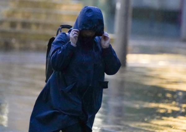  A member of the public battles with the strong winds as she walks in Manchester city centre. 