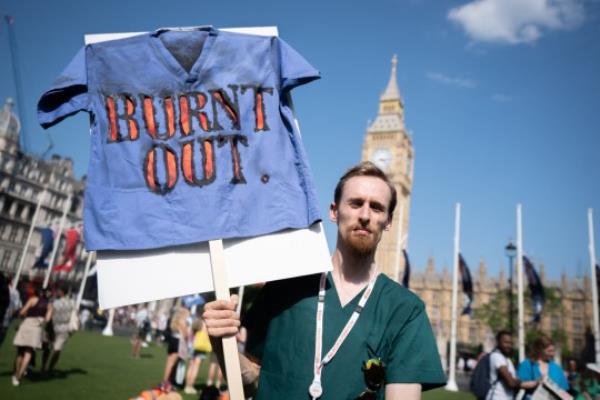 A striking junior doctor from the British Medical Association takes part in a rally in Parliament Square, Westminster, during a 72-hour stoppage in a row with the Government over pay. Picture date: Friday June 16, 2023. PA Photo. The British Medical Association (BMA) has said it will ballot training doctors next week to extend its strike mandate. If members vote to co<em></em>ntinue strikes, junior doctors could take to picket lines for three days a month, every month, until March 2024. See PA story INDUSTRY Strikes. Photo credit should read: James Manning/PA Wire .