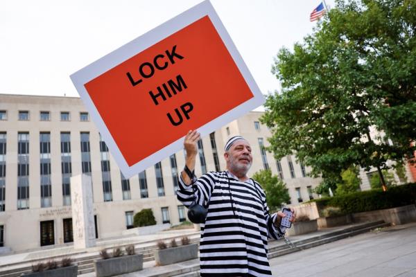 Domenic Santana of Miami holds a sign that reads 