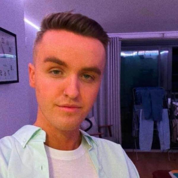 A man with a short hair cut taking a selfie.