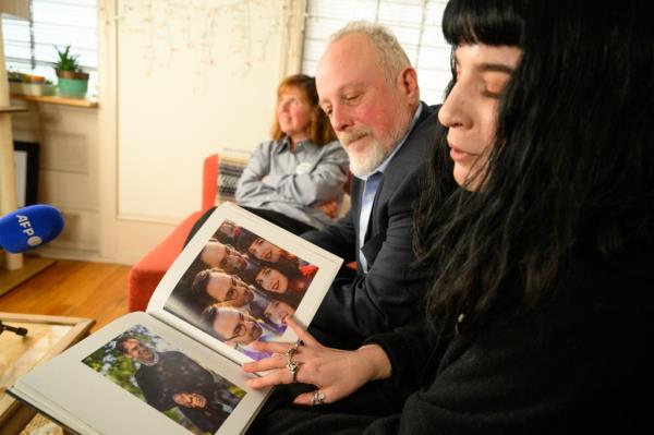 Mikhail and Danielle Gershkovich, father and sister of detained journalist, Evan Gershkovich, look at photos of Evan in her wedding album in Danielle's apartment in Philadelphia.