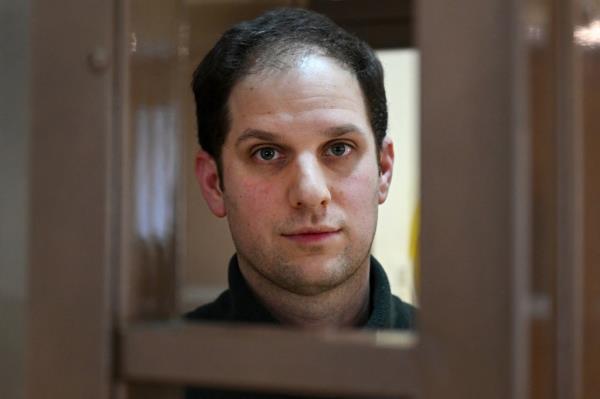 US journalist Evan Gershkovich, arrested on espio<em></em>nage charges, looks out from inside a defendants' cage before a hearing to co<em></em>nsider an appeal on his extended pre-trial detention.