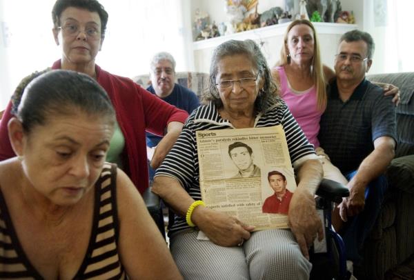 Relatives on Ernie Pelton photographed at home in 2007 after Ernie died. The Mom holds a picture of Ernie as a teen.