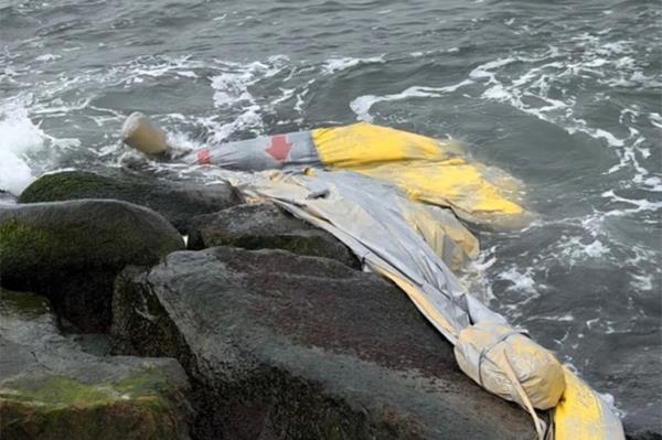 Picture of the slide in the water washed up against stone breakers.