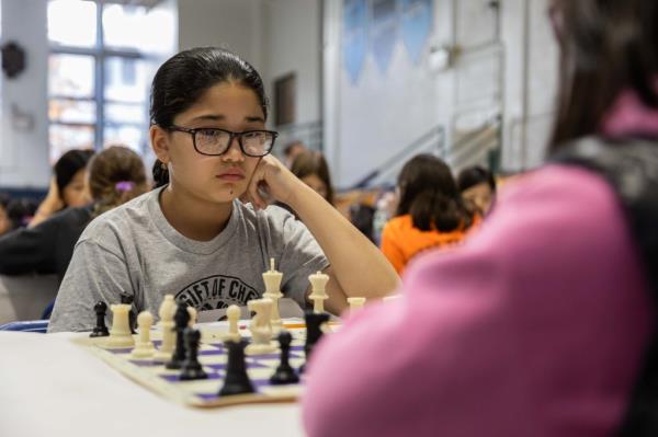 Mariangel studies chessboard while facing off with oppo<em></em>nent during competition.