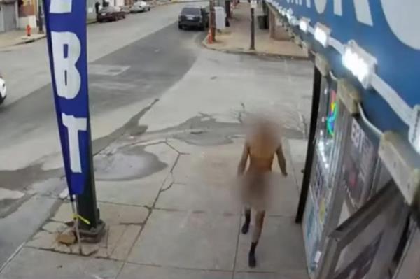 Russom Gebretsadik standing naked outside store