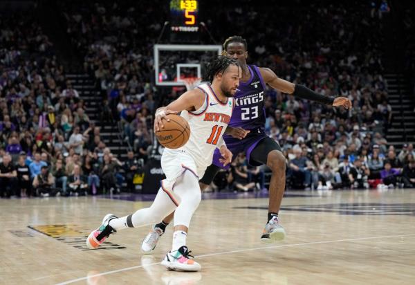 Jalen Brunson dribbling the ball is guarded by Keon Ellis #23 of the Sacramento Kings during the second half of an NBA basketball game at Golden 1 Center on March 16, 2024 in Sacramento, California.