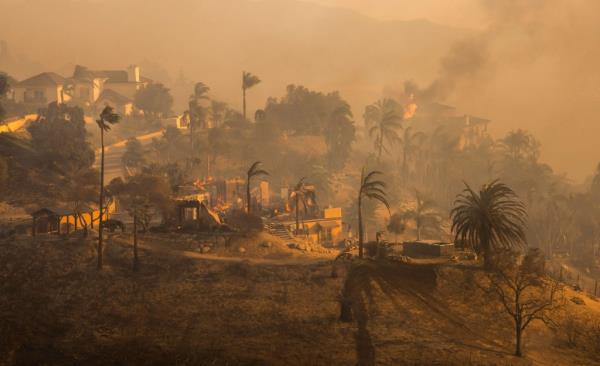 Television reporters film as flames from the Mountain Fire co<em></em>nsume a home in Camarillo, Calif., on Wednesday, Nov. 6, 2024.