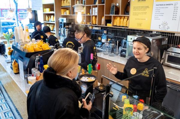 Crew member Rachel Barcellona, right, talks to a customer while at the register.