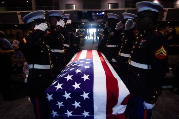 A military ho<em></em>nor guard salutes next to the flag-draped casket of Marine Lance Cpt. Kareem Grant Nikoui during a funeral ceremony inside the Harvest Christian Fellowship on September 18, 2021 in Riverside, California. - Nikoui was one of 13 US service members killed in the suicide blast in Kabul during the evacuation of US citizens, and Afghan civilians on August 26.