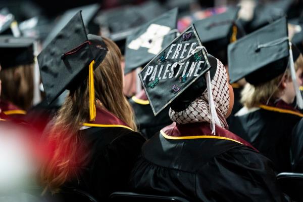 A student sits with her cap decorated to read 