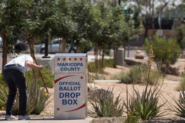 Voters casting their mail-in ballots at a drop box outside the Maricopa County Recorder and Elections Department office in Mesa, Arizona.