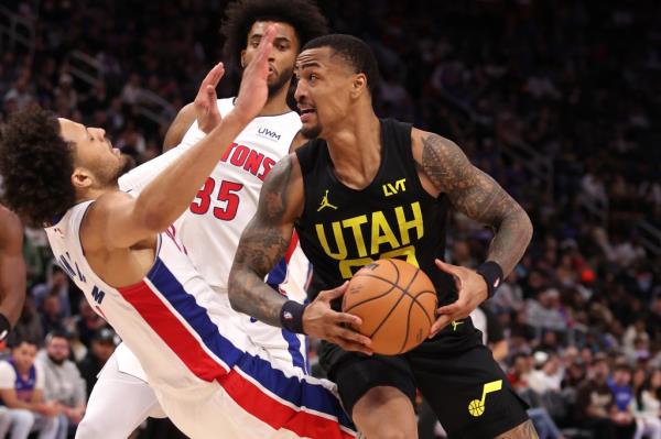 John Collins #20 of the Utah Jazz drives against Cade Cunningham #2 of the Detroit Pistons