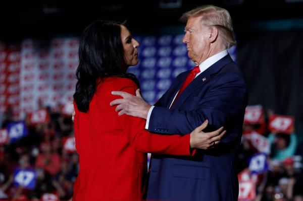 Former U.S. Representative Tulsi Gabbard and ex-President Do<em></em>nald Trump embracing at a campaign rally in Greensboro, North Carolina on October 22, 2024.