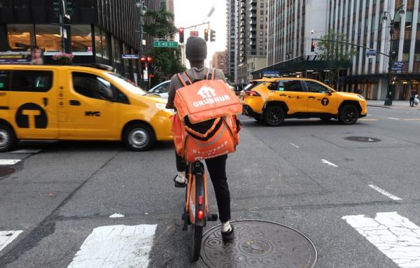 GrubHub delivery person riding an e-bike along Third Avenue in New York City