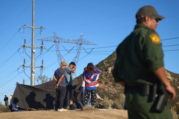 Migrants wait to be processed by US Border Patrol in Jacumba, Calif.