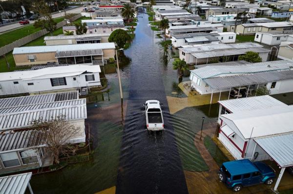 A car driving through a flooded neighborhood in South Daytona, Florida on Oct. 11, 2024.