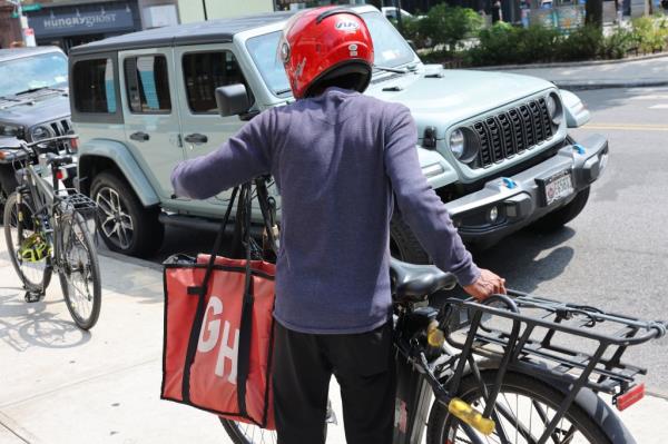 Food delivery worker picking up an order in Park Slope, Brooklyn, New York on July 29, 2024 amidst rising third-party delivery prices