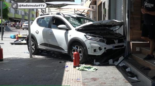 A woman in a pink dress could be seen on the ground, surrounded by debris as the man remains on the hood of the vehicle.