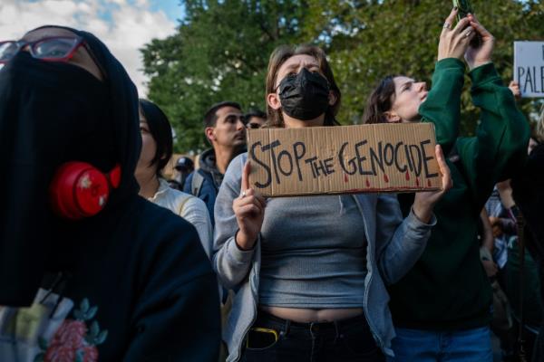 A protestor holds a 'Stop the Genocide' sign at the Washington Square Park rally. 