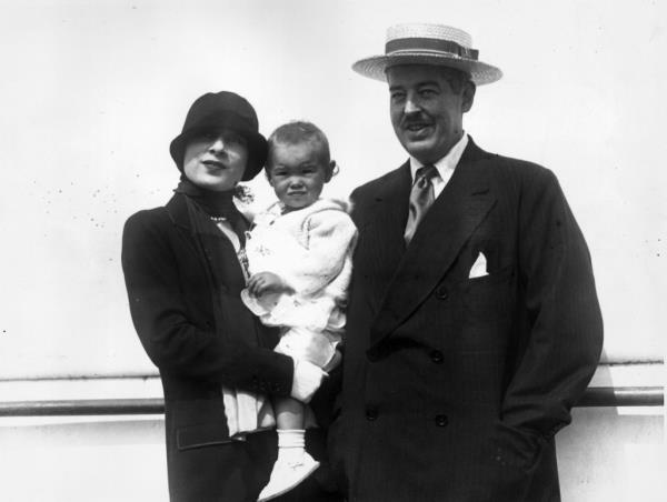 Married couple Gloria Morgan Vanderbilt and Reginald C Vanderbilt standing outdoors, posing with their baby daughter, Gloria Vanderbilt. 