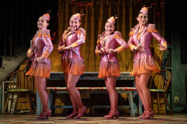 Four girls in pink outfits dancing.