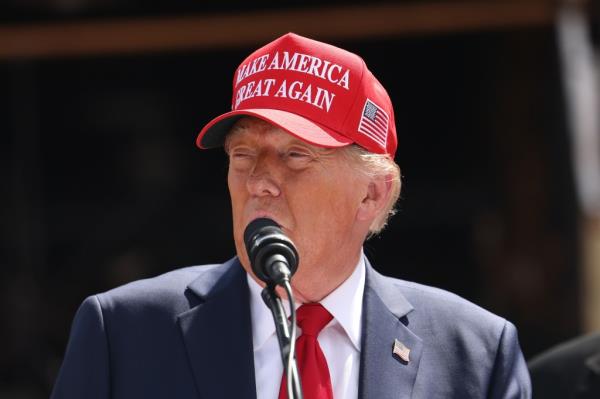 Former U.S. President Do<em></em>nald Trump speaking into a microphone during a visit to Chez What Furniture Store, which was damaged by Hurricane Helene, in Valdosta, Georgia