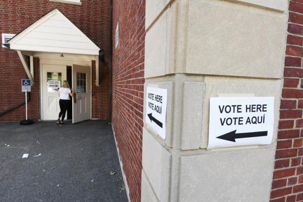 A woman walking into Fox Meadow School in Scarsdale, NY, to vote, seen from behind. 