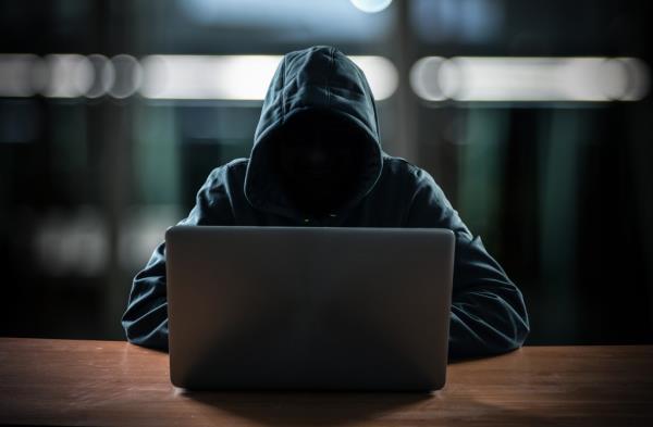 Person wearing hoodie looking at laptop