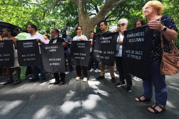 People holding up names of people who have died at Rikers Island at a press co<em></em>nference on June 1, 2023 following the latest death.