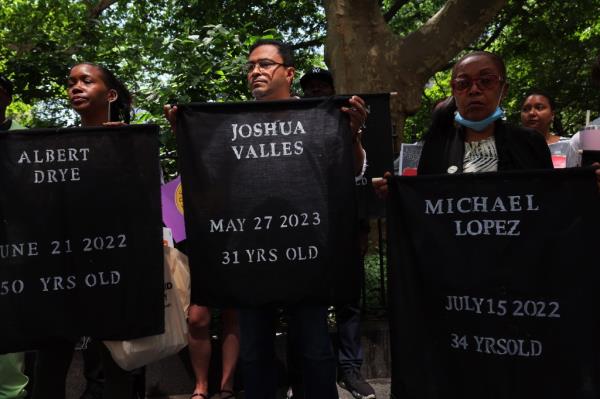 A banner held for Paul Valles, who died at Rikers on May 27.