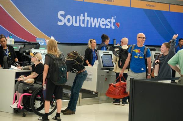 Travelers queue up at a Southwest Airlines ticket counter in Denver last year.