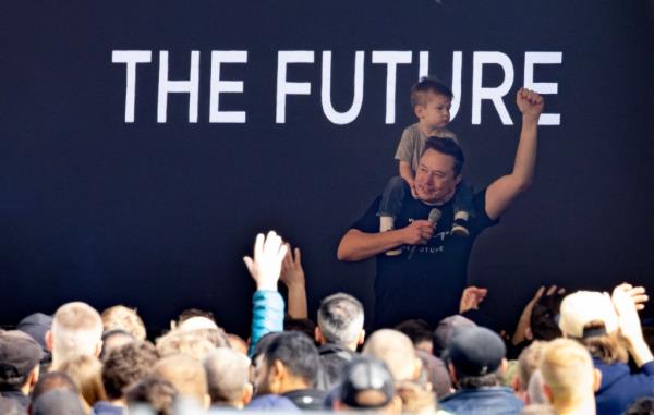 Tesla CEO Elon Musk carries on his shoulders his son X ? A-XII as he addresses employess