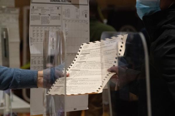 A poll worker hands a ballot to a voter at Public School 33 in Chelsea on Election Day.