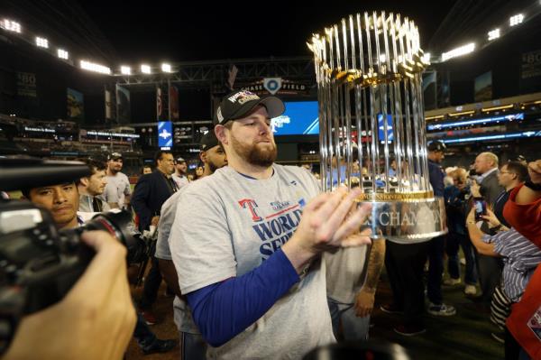 Texas Rangers pitcher Jordan Mo<em></em>ntgomery holds up the World Series trophy.