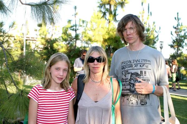 Coco Hayley Gordon Moore, Kim Gordon and Thurston Moore outside amidst greenery. 