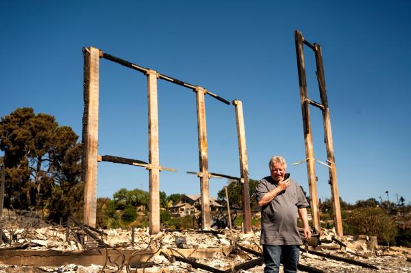 Joey Parish pho<em></em>nes his wife, Friday, Nov. 8, 2024, while standing in front of his home, which was destroyed by the Mountain Fire in Camarillo, Calif. 