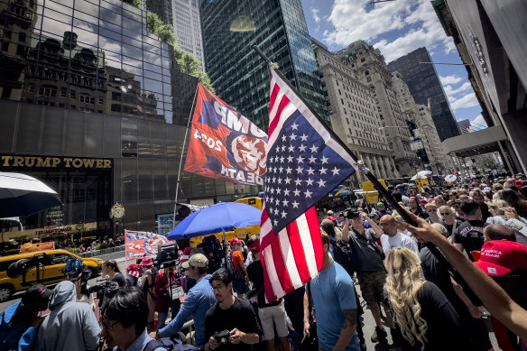 A supporter of Do<em></em>nald Trump waves an inverted American flag during a demo<em></em>nstration outside Trump Tower.