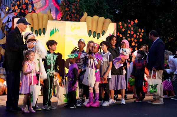 President Joe Biden poses for a photo with trick-or-treaters on the South Lawn of the White House.