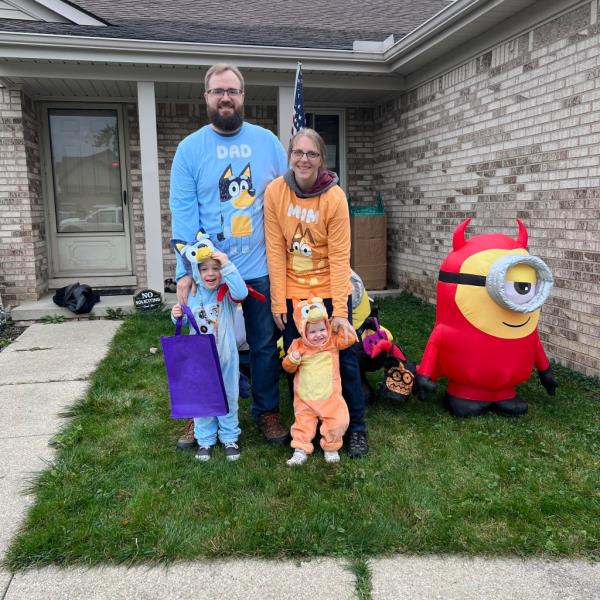 A family posing for a picture in front of a house