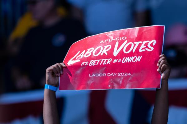 A supporter holds up a sign as Democratic vice presidential nominee Minnesota Gov. Tim Walz Walz speaks at Laborfest on September 2, 2024 in Milwaukee, Wisconsin. 