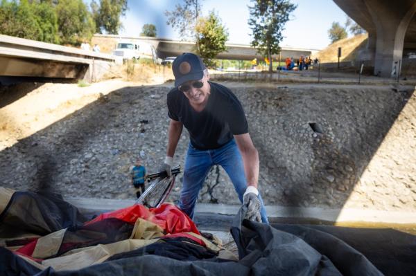 Governor Gavin Newsom cleans up an encampment site near Paxton Street and Remick Avenue in Los Angeles as the state's Clean California initiative co<em></em>ntinues on Thursday, Aug. 8, 2024 in Los Angeles, CA