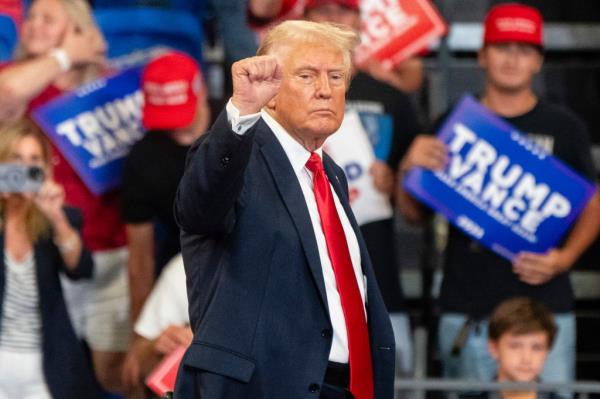 Former President Do<em></em>nald Trump raising his fist while leaving the stage at a campaign event in Atlanta, GA