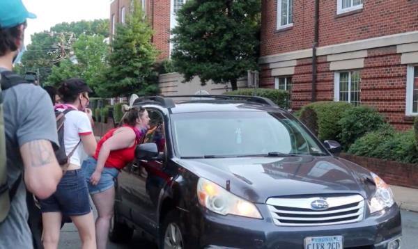 Black Lives Matter protesters are seen co<em></em>nfronting Morgan Bettinger, who is sitting inside her car.