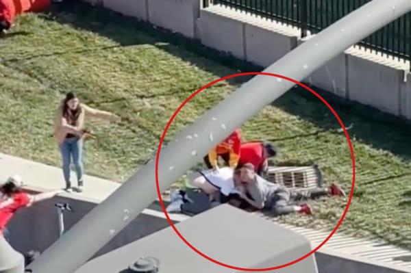 A group of people laying on the ground during Kansas City Chiefs Parade after a shooting incident at Unio<em></em>n Station, tackled a running man.