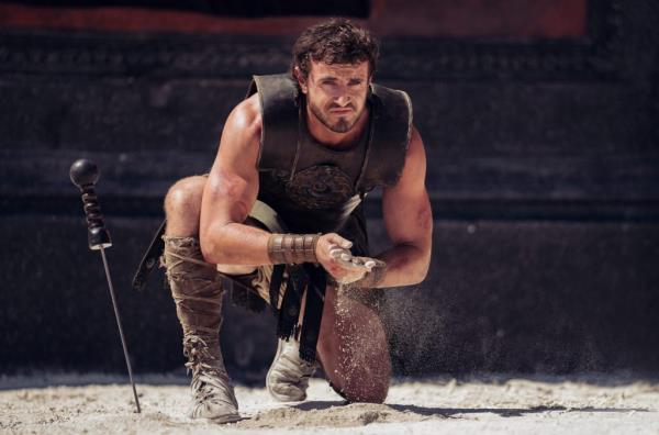 Paul Mescal portraying Lucius Verus II in the film Gladiator II, kneeling in sand