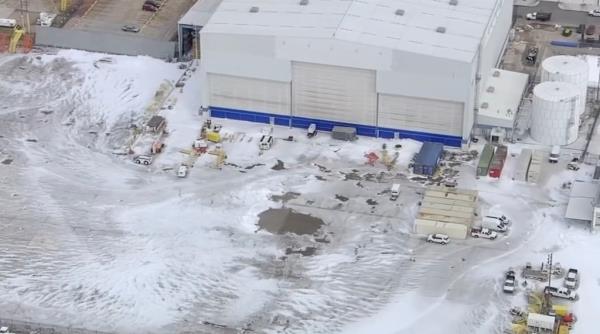 Aerial view of foam covering ground outside airport hangar 