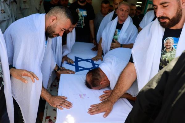 A bloodied child is carried away after being caught in an Israeli airstrike in Gaza. 