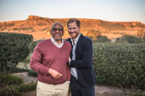 Prince Seeiso of Lesotho and Prince Harry, Duke of Sussex, standing in front of bushes at a cultural event in Maseru, Lesotho