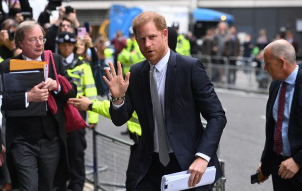 Prince Harry, Duke of Sussex, in a suit waving as he arrives at the High Court in London, United Kingdom on June 7, 2023